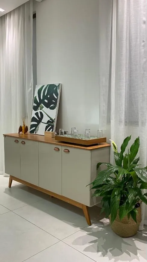 Aparador com copos de água, quadro e planta