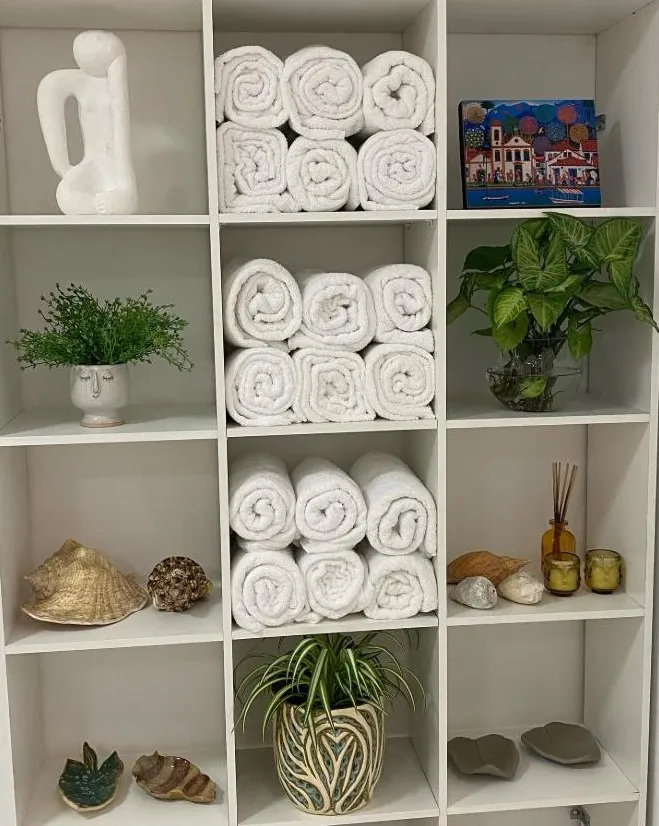 Estante com toalhas brancas e plantas